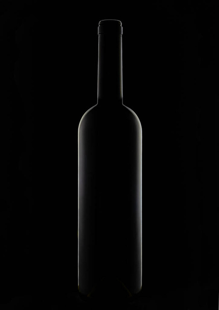 Dark glass bottle on a dark background close-up. - Zdjęcie, obraz