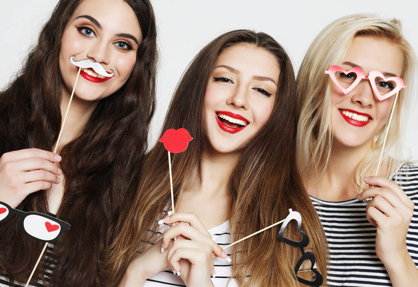 Three young women holding paper party sticks - Fotografie, Obrázek