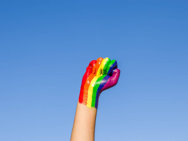Photo d'un poing levé coloré avec la couleur arc-en-ciel pour la communauté lgbtq. - Photo, image