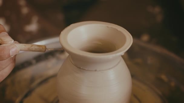 Garncarz podejmowania ceramiczne wazon przy użyciu narzędzi ceramicznych w pomieszczeniach, zbliżenie - Materiał filmowy, wideo