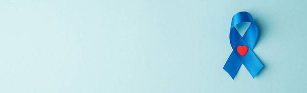 Top view panoraama kuva sininen Satiini nauha ja pieni punainen sydän symboli eturauhassyövän tietoisuutta eristetty pastelli sininen tausta tyhjä tila - Valokuva, kuva