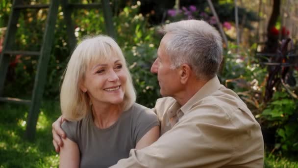 庭で屋外をリラックスしながらキスと抱擁ロマンチックなシニア配偶者 - 映像、動画