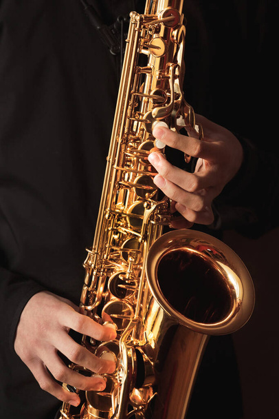 saxophonist, musician playing the saxophone, hands close-up, wind instrument, music background - Foto, imagen