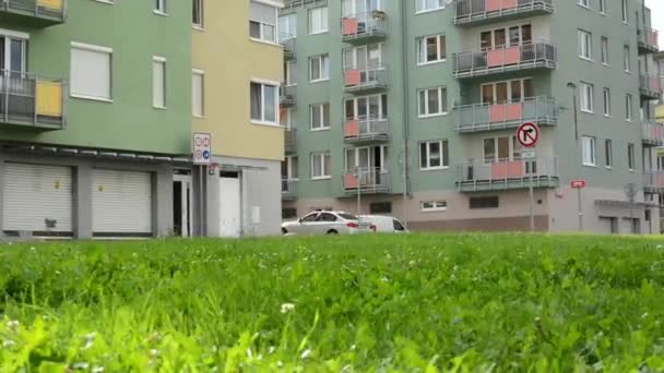 緑のアパートの高層ブロック駐車した車の草 - スライダーを移動 - 映像、動画