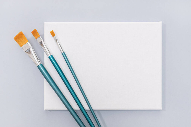 Blank White canvas and paint brushes isolated on gray background. Template, mock up - Photo, Image