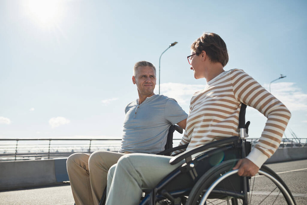Взрослая пара в инвалидных колясках на улице - Фото, изображение