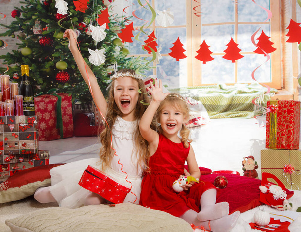 Kerstmis of Nieuwjaarsscène. Mooie meisjes zussen in Kerst interieur - Foto, afbeelding