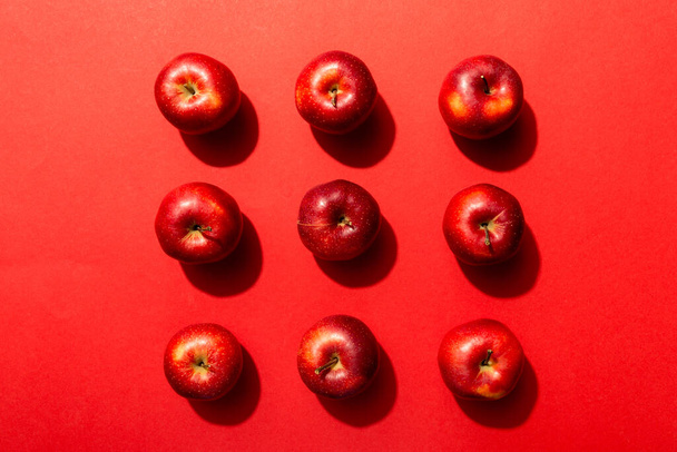 Muchas manzanas rojas sobre fondo de color, vista superior. Patrón de otoño con manzana fresca por encima de la vista. - Foto, Imagen