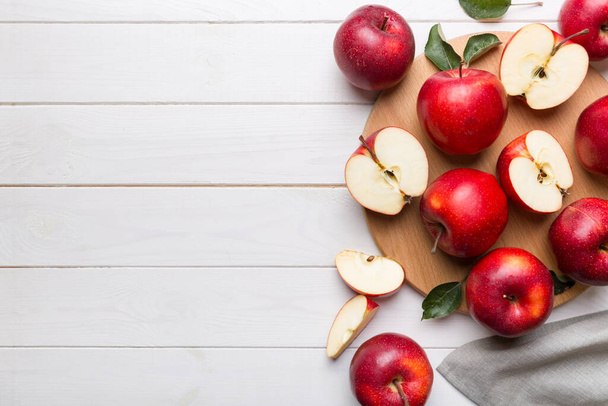 テーブルの上に緑の葉を持つ新鮮な赤いリンゴ。ナイフで板を切る。トップ表示. - 写真・画像
