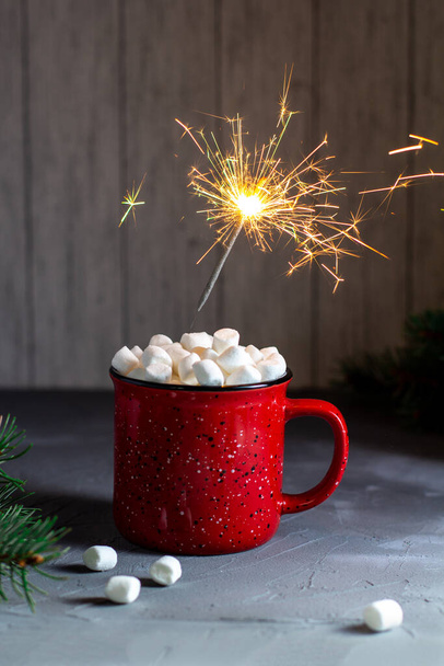 Κόκκινη κούπα χριστουγεννιάτικο καφέ ή κακάο με ζαχαρωτά και sparklers σε γκρι πέτρινο τραπέζι. Χριστούγεννα έννοια διακοπών - Φωτογραφία, εικόνα