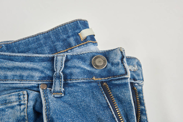 Bouton jean bleu isolé sur fond blanc, plié, tendance, élégant, denim à la mode. - Photo, image