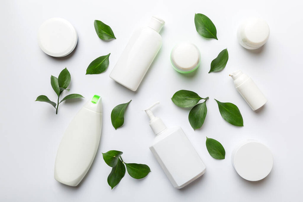 Bio-Kosmetikprodukte mit grünen Blättern auf weißem Hintergrund. Flache Lage. - Foto, Bild