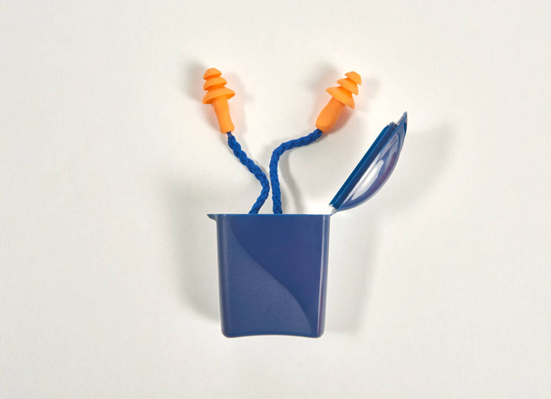 Earplug and box isolated on the white background, blue and orange product. - Photo, Image