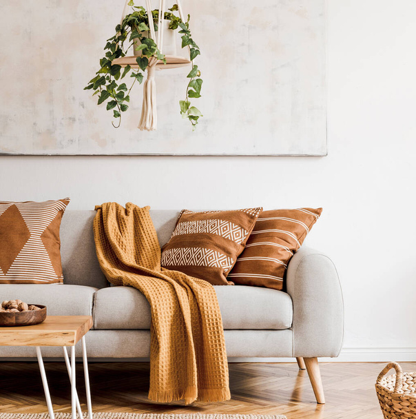 Stylish composition of creative and cozy living room interior with grey sofa, coffee table, plants, carpet and beautiful accessories. White walls and parquet floor. - Valokuva, kuva