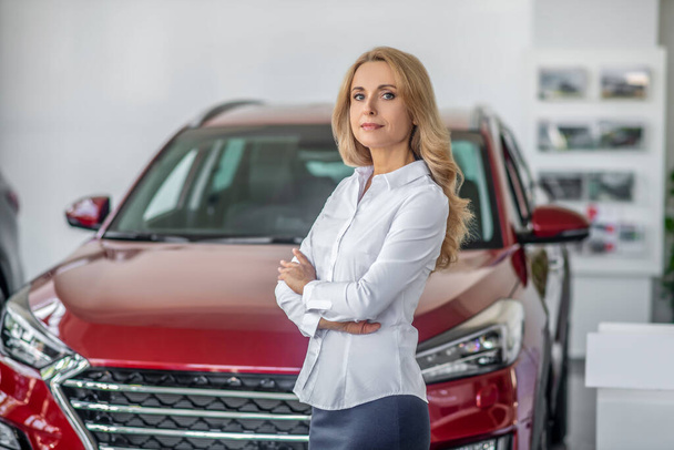 Blonde business woman in car dealership - Фото, зображення