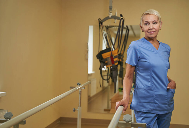 Mature woman physiotherapist works in medical center - Valokuva, kuva
