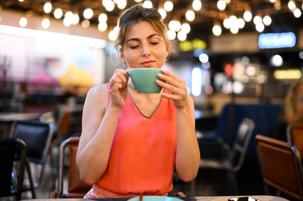Beautiful woman having a coffee in a cafe - Фото, зображення