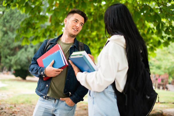 Couple of students talking together in a park outdoor - Photo, Image