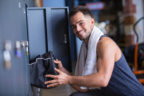 sportsman putting his bag into a locker - Foto, Imagem
