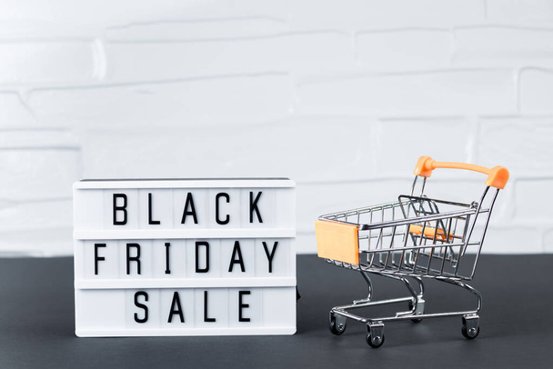 Sale and Black Friday concept. Mini shopping cart on a white background. - Φωτογραφία, εικόνα