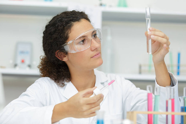 woman in lab looking at pipete - Φωτογραφία, εικόνα