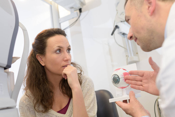 doctor showing eye model to patient - Foto, Imagen