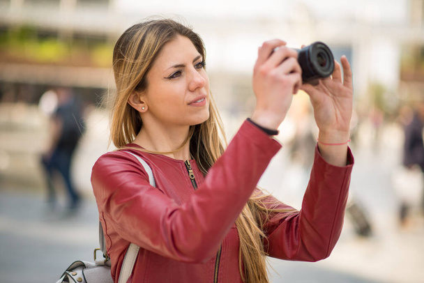 Nainen käyttää hänen kompakti kamera kaupungissa - Valokuva, kuva