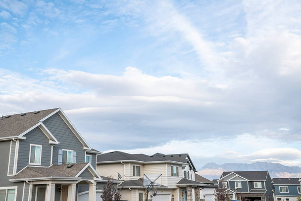 Bright cloudy sky above the residential area against the mountains at the background - Photo, Image