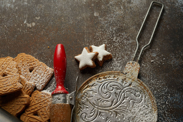 Festive cookies, baking tools, and sugar powder on the table; preparations for Christmas - Valokuva, kuva