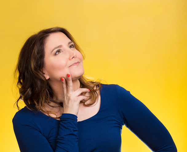 Happy, middle aged woman looking upwards daydreaming - 写真・画像