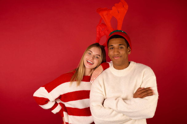 Két fiatal szarvas kalapban, piros háttérben. - Fotó, kép