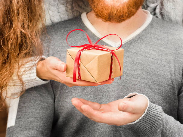 жіноча рука дає подарункову коробку чоловікові крупним планом
 - Фото, зображення
