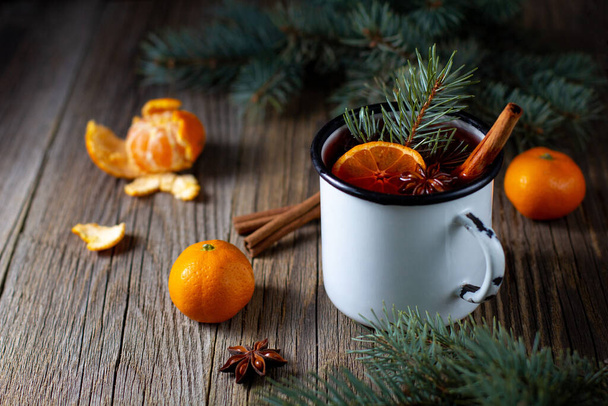 伝統的なおいしい白のカップでみかんのリンゴのスパイスとクリスマスツリーとマルチワイン。秋のホットドリンク - 写真・画像
