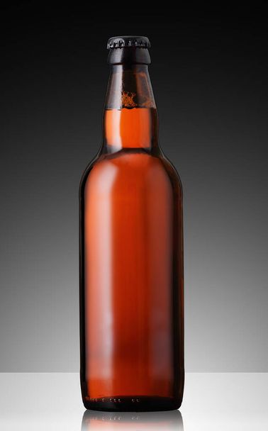 Braune volle Bierflasche auf grauem Hintergrund - Foto, Bild