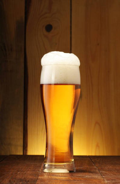 hrnek s lehkým pivem a pěnou na pozadí prken s gradientem - Fotografie, Obrázek