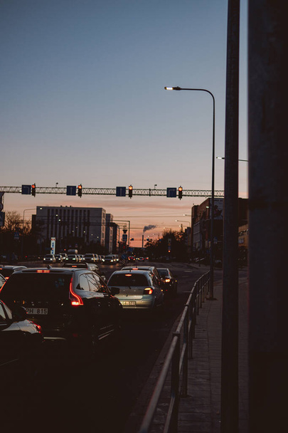 A silhouette of a traffic light on a busy street in a city at dusk - Foto, Imagem