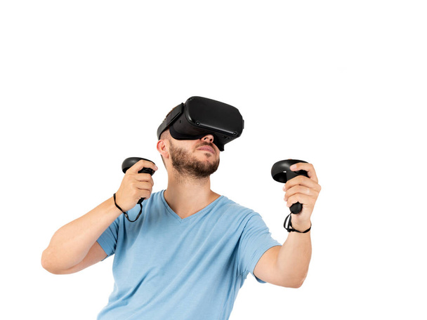 Νεαρός που παίζει με γυαλιά εικονικής πραγματικότητας σε λευκό φόντο - Φωτογραφία, εικόνα