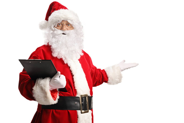 Santa claus holding a clipboard and showing with hand isolated on white background - Φωτογραφία, εικόνα
