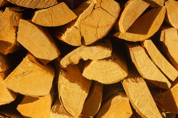 A close up shot of stacked together firewood under the sun light. Perfect for wallpaper. - Foto, Bild
