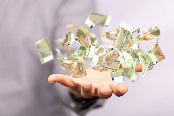 A man hand on blurred background holding cashflow euro banknote bill in hand - Foto, Imagem