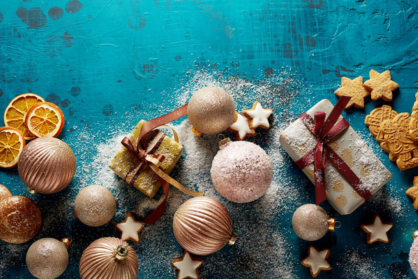 Tasty Christmas cookies, baubles, and gift boxes on the grunge surface; blue background with a copy space - Φωτογραφία, εικόνα