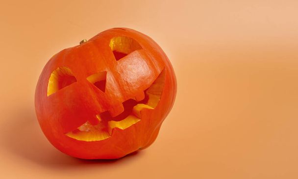 Jack lantern carved from a ripe pumpkin on an orange background. Copy space. Halloween concept. - Photo, Image