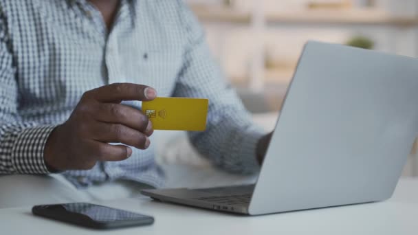 Tanınmayan kıdemli Afrikalı Amerikalı adam evde kredi kartı ve laptopuyla online ödeme yapıyor. - Video, Çekim
