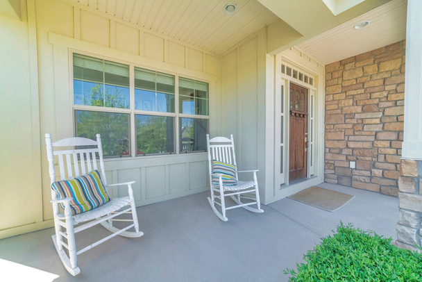Πρόσοψη εξωτερικού χώρου σπιτιού με ξύλινη μπεζ επένδυση και ξύλινη μπροστινή πόρτα με υαλοπίνακες - Φωτογραφία, εικόνα