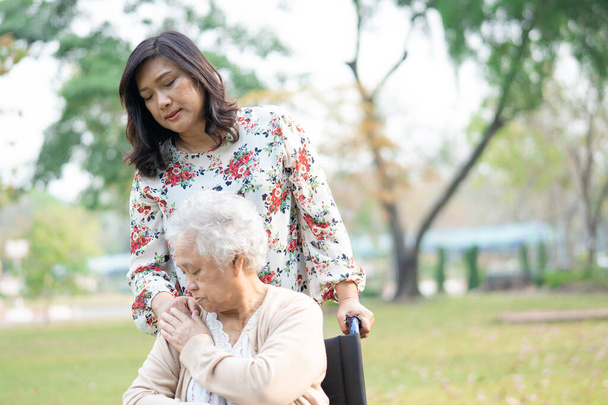 Idős ázsiai idős vagy idős hölgy beteg gondozás, segítség és támogatás a gondozó tolószék a parkban nyaralás, egészséges erős orvosi koncepció. - Fotó, kép