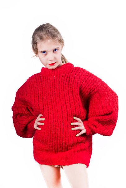 op een witte achtergrond. Het meisje in de rode trui. De handen zitten aan de riem. leeftijd 8 jaar. close-up. - Foto, afbeelding