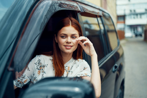 cheerful woman driving a car looks out of the window - 写真・画像