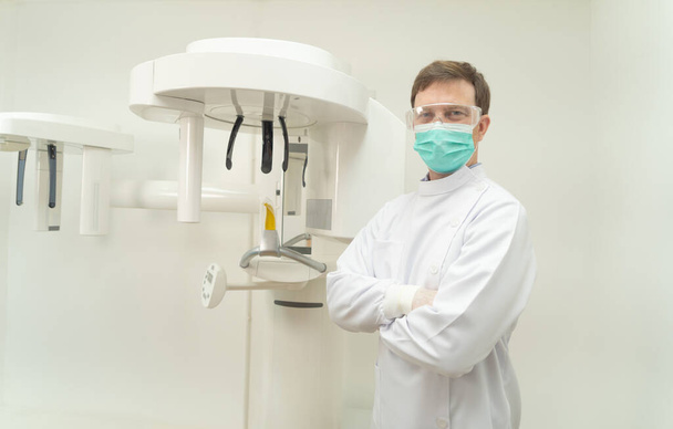 Retrato del hombre dentista caucásico feliz, gente sonriendo en la clínica del hospital. Doctor aislado en la máquina de escáner de rayos X dental en laboratorio. Odontología. Médico y de salud. Los dientes examinan - Foto, Imagen