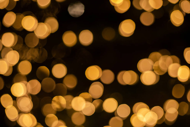Árbol de Navidad fondo bokeh, abstracto luces desenfocadas doradas brillantes en negro - Foto, imagen