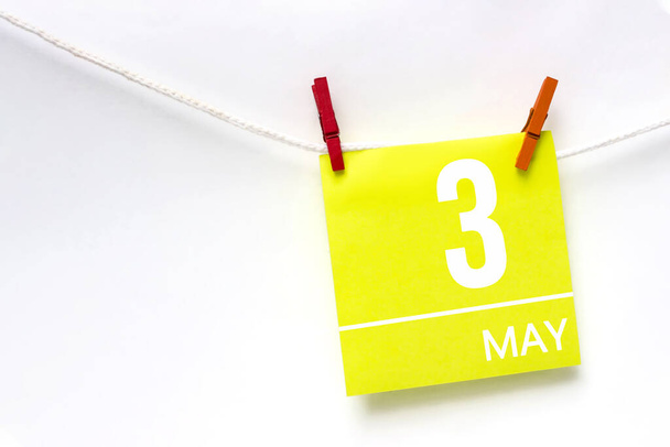 3 мая. День 3 месяца, дата календаря. Бумажные карточки с календарным днем веревки с прищепками на белом фоне. Весенний месяц, концепция дня года - Фото, изображение